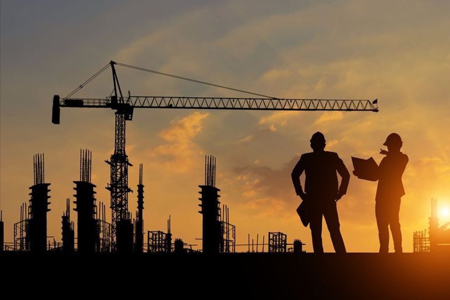 A construction crane at sunset on a building site